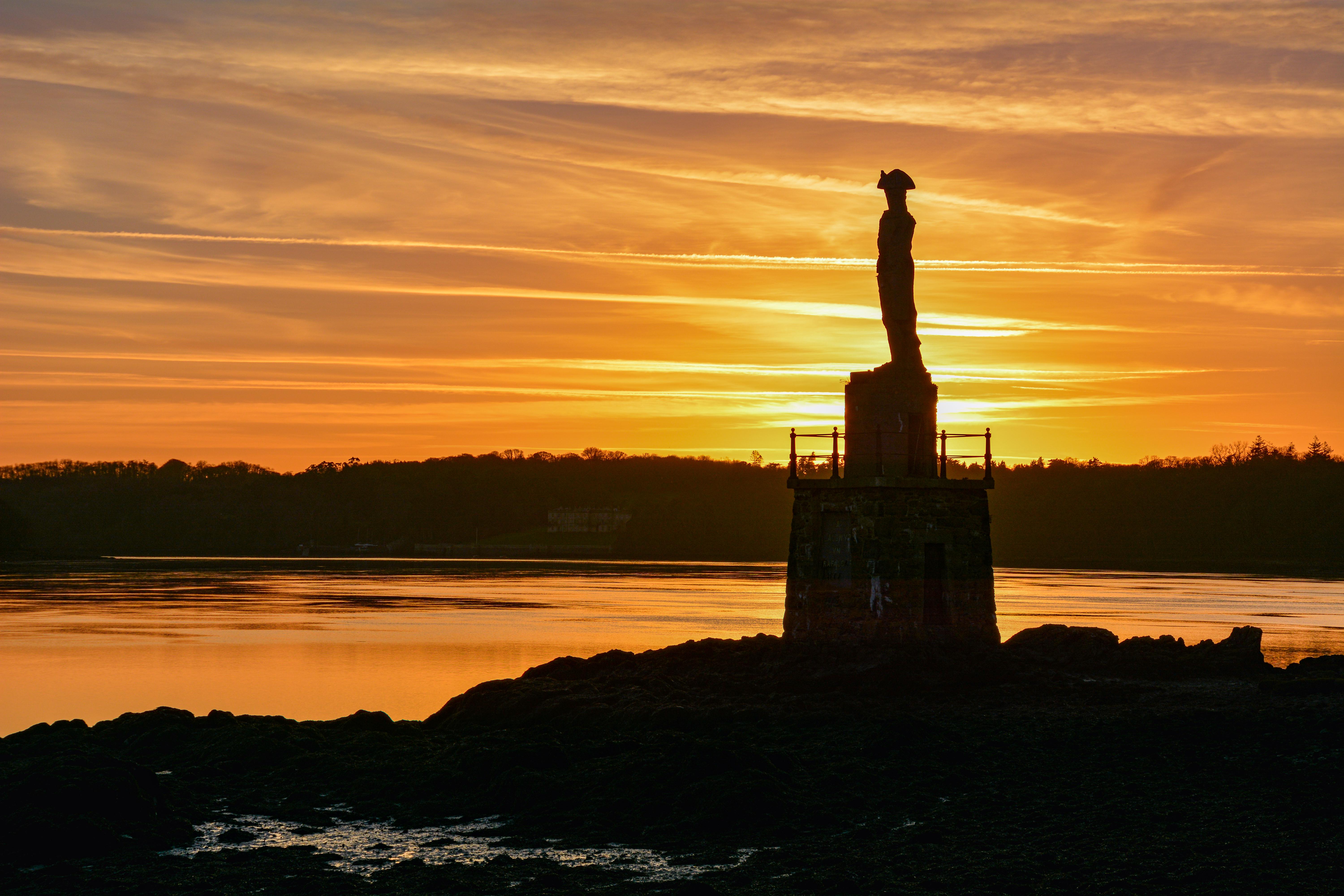 sunset over nelsons statue on the menai strait on anglesey
